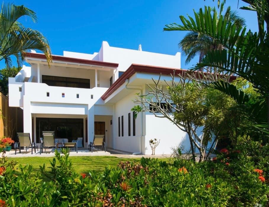 Hermosa Palms white villa with tropical landscaping and palm trees in Playa Hermosa