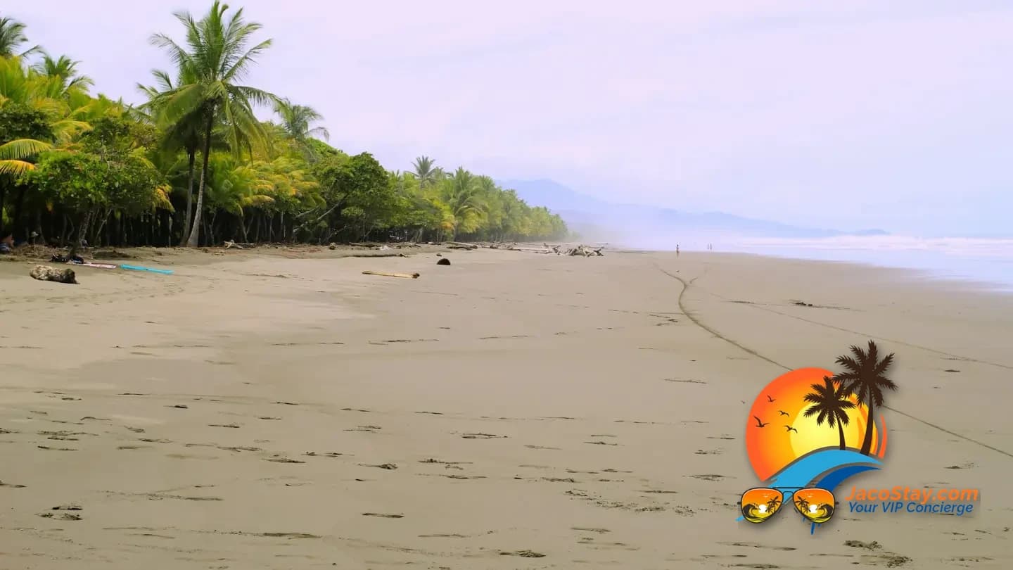 Couple walking the shoreline at sunset on Jaco Beach, Costa Rica
