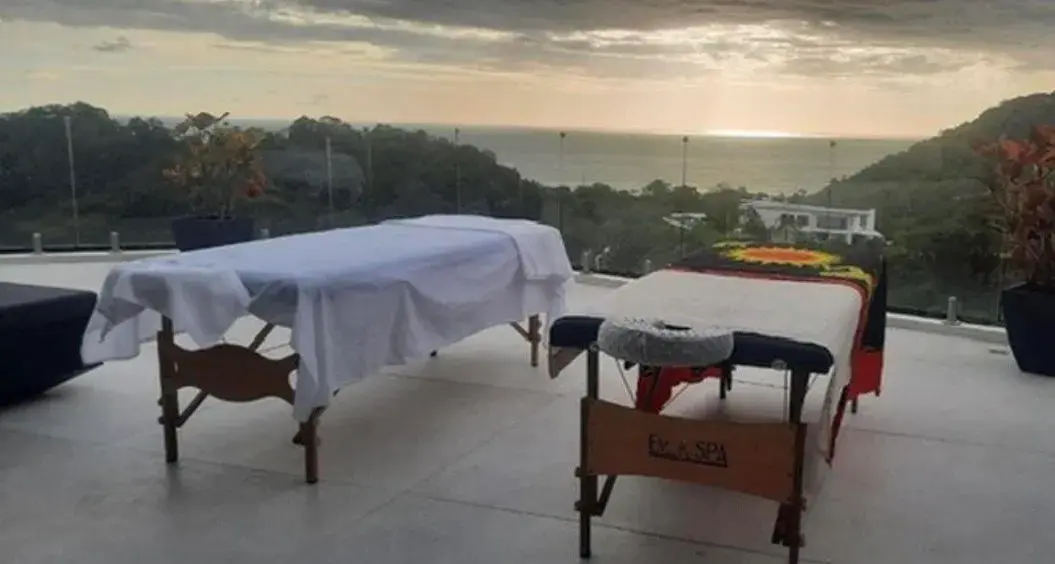 Side-by-side spa massage tables on an outdoor terrace at sunset in Costa Rica