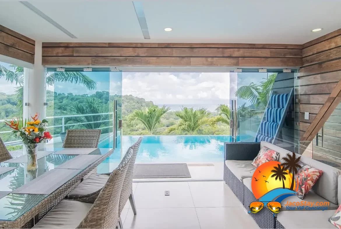 Romantic tropical outdoor dining setup overlooking an infinity pool and jungle